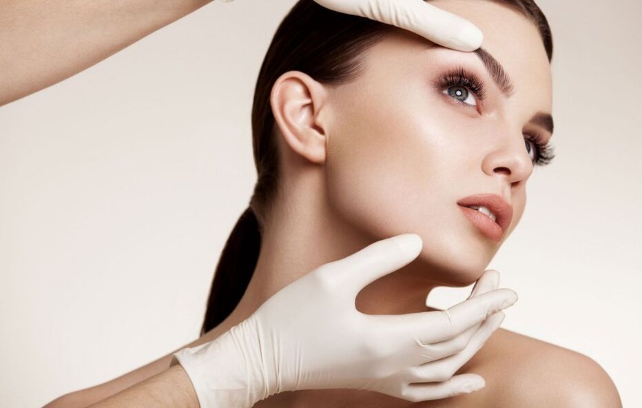 Beautician examining facial skin before rejuvenation